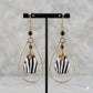 Gold brass teardrop earrings with black and white striped bone beads and black accents.