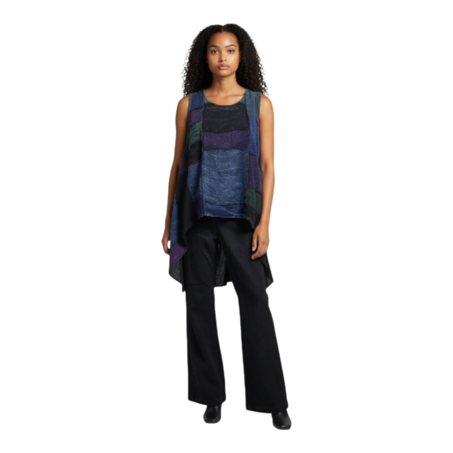 Woman wearing a sleeveless, multicolored top with black pants on a white background