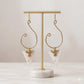 Kenyan brass, and bone drop earrings with triangular bone pendants on a gold stand.