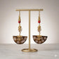 Kenyan brass, cowrie shell, and bone drop earrings with red beads and spiral designs.
