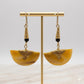 Kenyan brass, and hand-carved bone drop earrings with black beads on a gold stand.