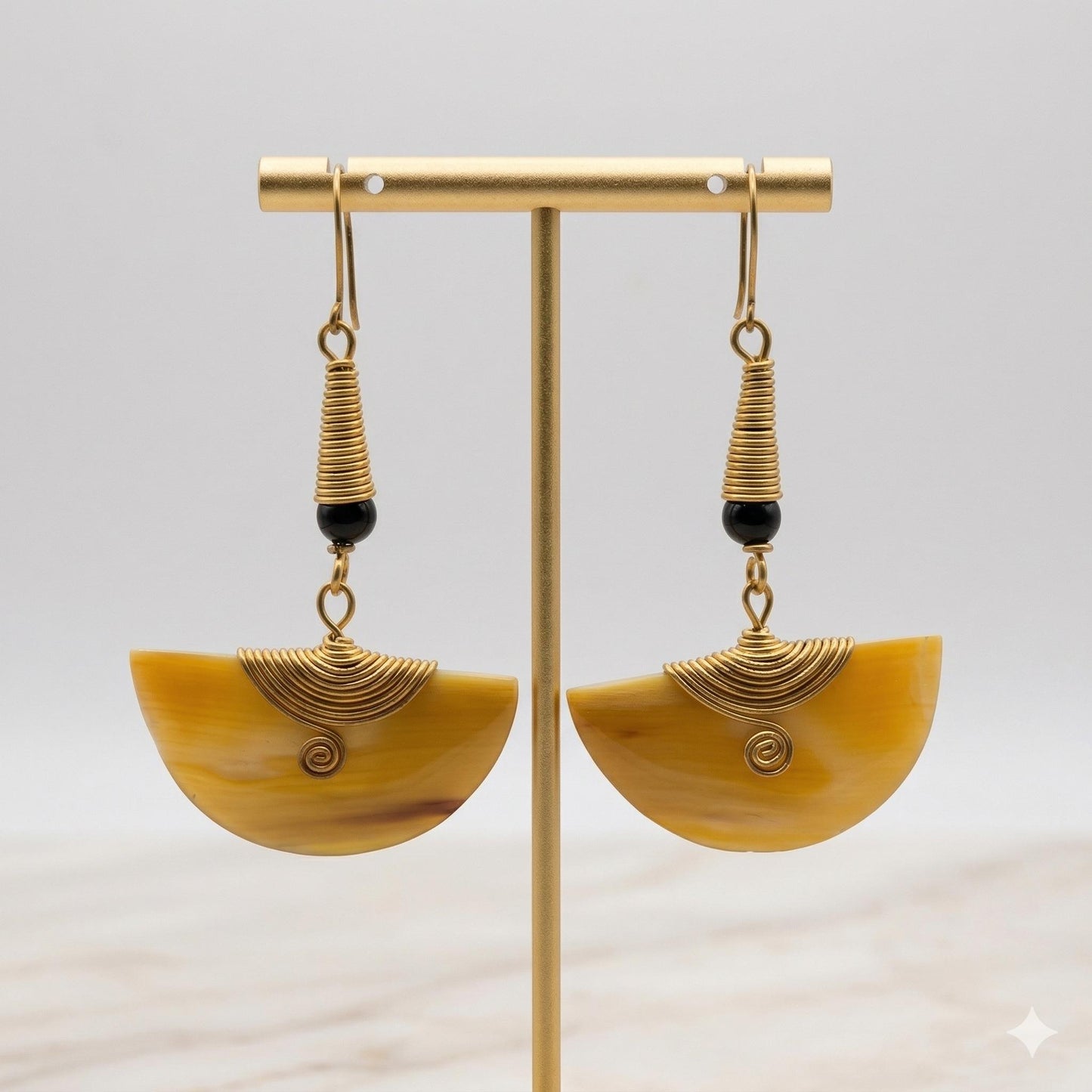 Kenyan brass, and hand-carved bone drop earrings with black beads on a gold stand.