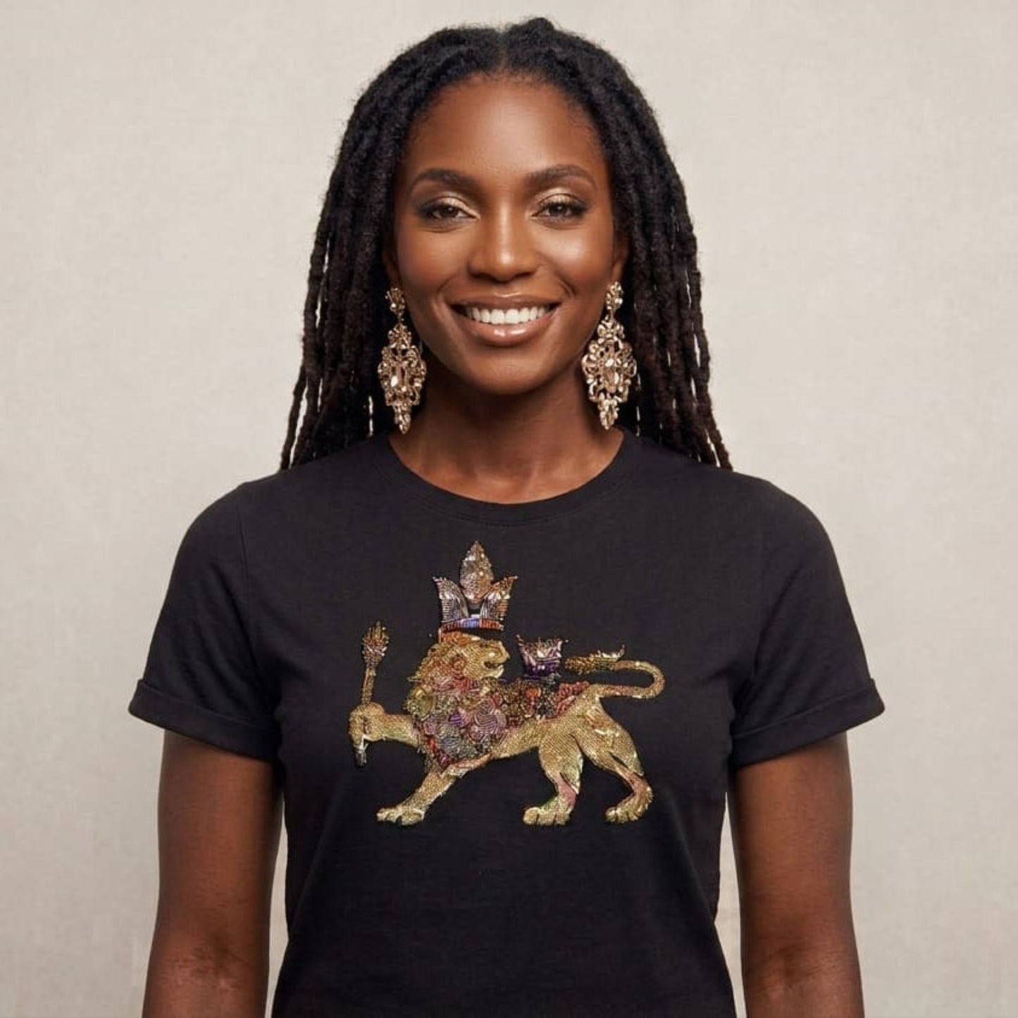 Woman wearing a black t-shirt with a colorful lion design on a beige background