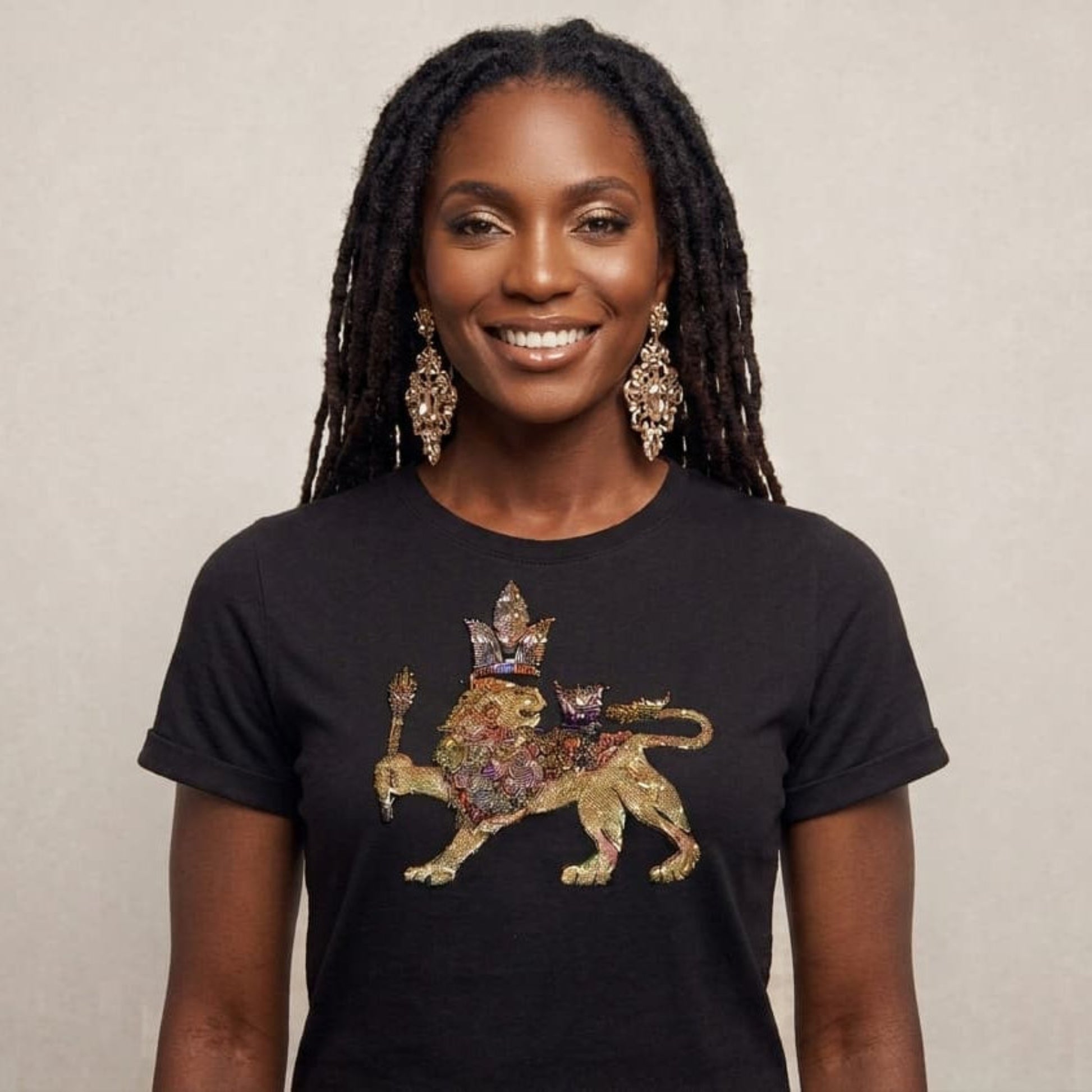 Woman wearing a black t-shirt with a colorful lion design on a beige background