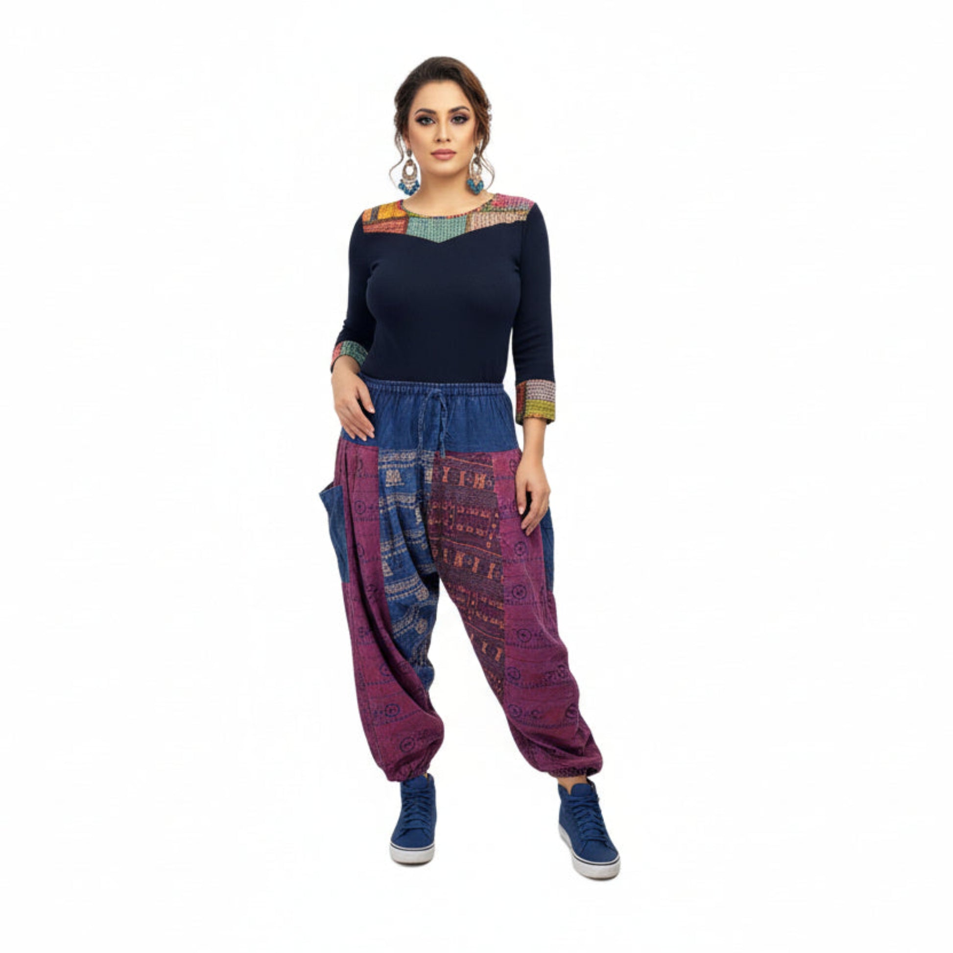 Person wearing colorful, patterned harem pants with a white backgrounde