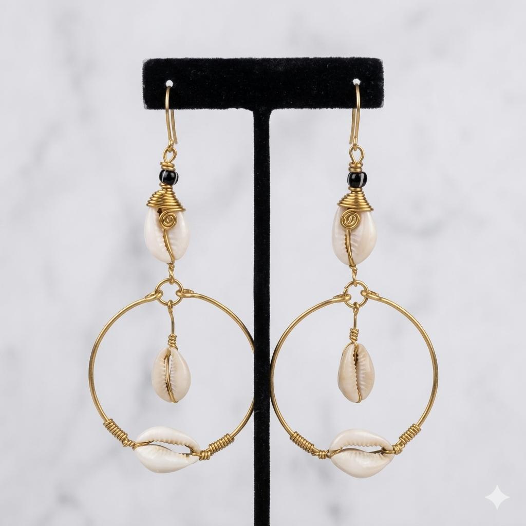 Pair of gold hoop earrings with shell accents on a black stand against a white background
