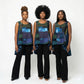 Three women wearing a colorful patchwork top and black pants on a white background