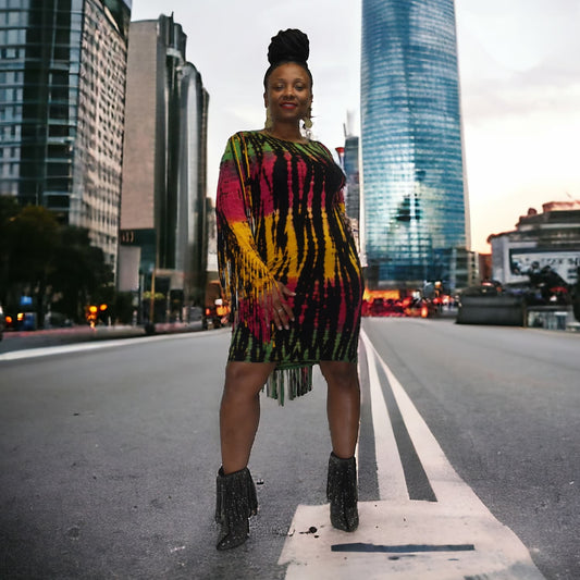 Woman in a colorful dress standing on a city street with tall buildings in the background. SanJules
