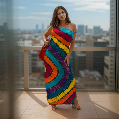 Woman wearing a colorful tie-dye dress standing on a balcony with a cityscape view.-Sanjules