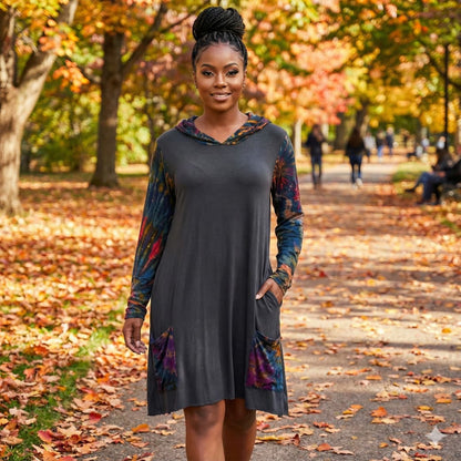 Woman in a gray dress with colorful patterns standing on a path with autumn leaves-Sanjules.