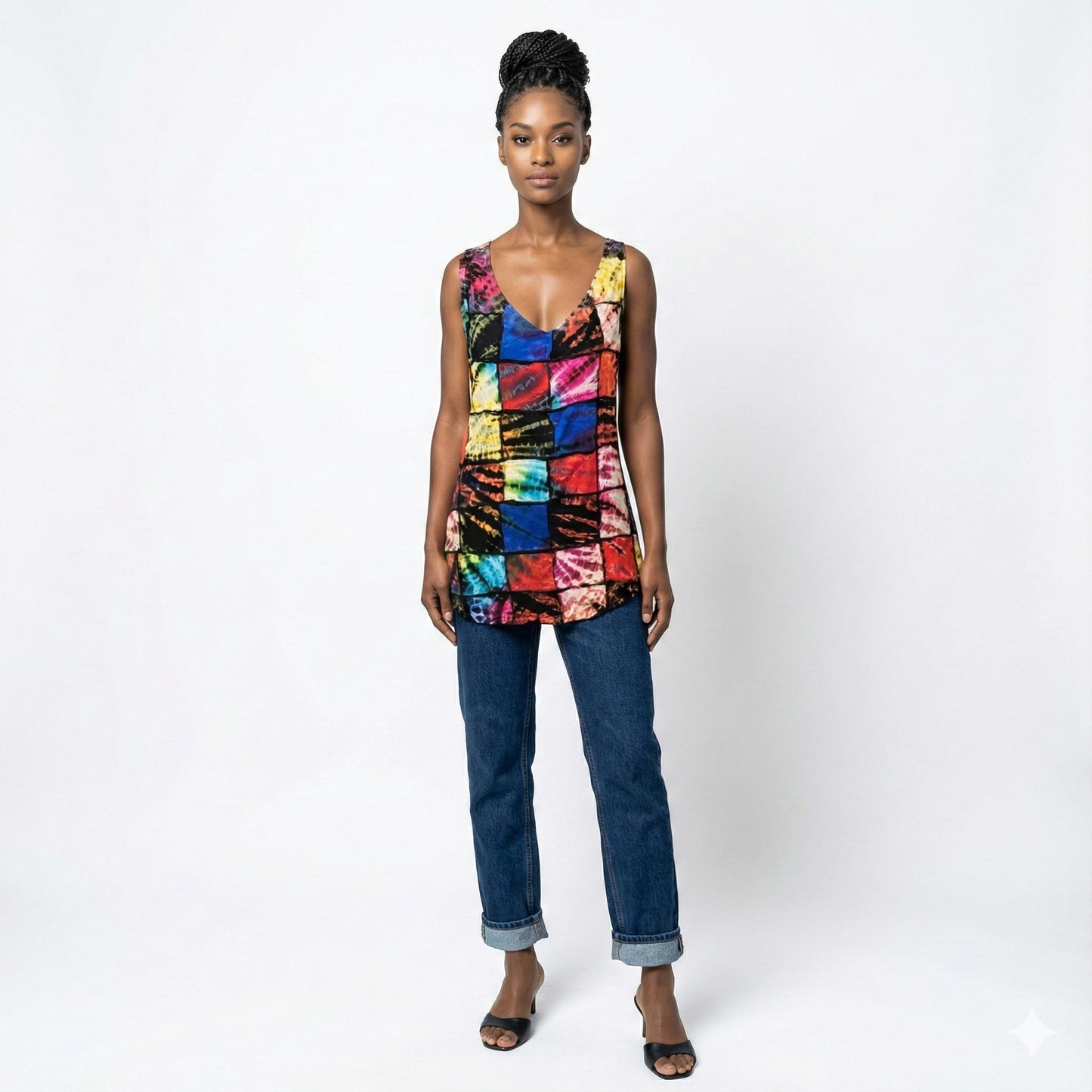 Woman wearing a colorful sleeveless top and jeans on a white background