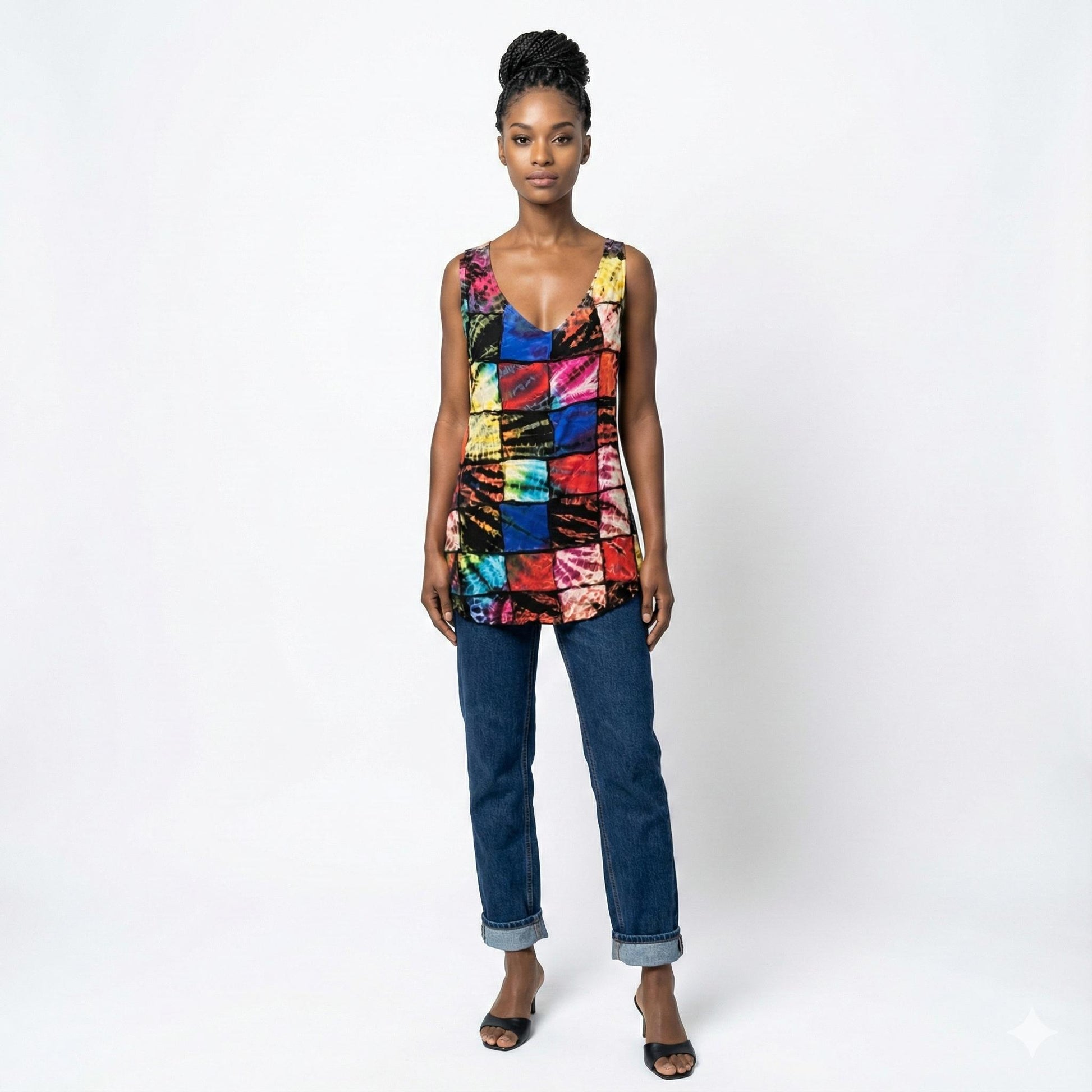 Woman wearing a colorful sleeveless top and jeans on a white background