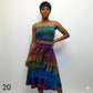 Woman wearing a colorful tie-dye tube top against a white background