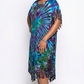 Woman wearing a colorful tie-dye dress with fringe on a white background