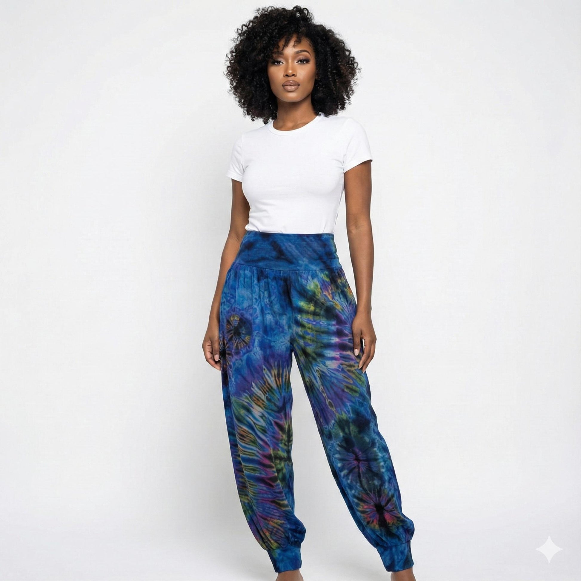 Woman wearing a white t-shirt and blue tie-dye pants on a white background