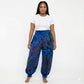 Person wearing blue tie-dye pants and a white shirt on a white background
