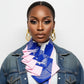Woman wearing a colorful necktief and denim jacket on a white background