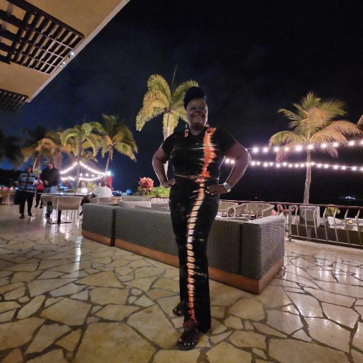 Woman wearing two piece pants set with palm trees in the backround