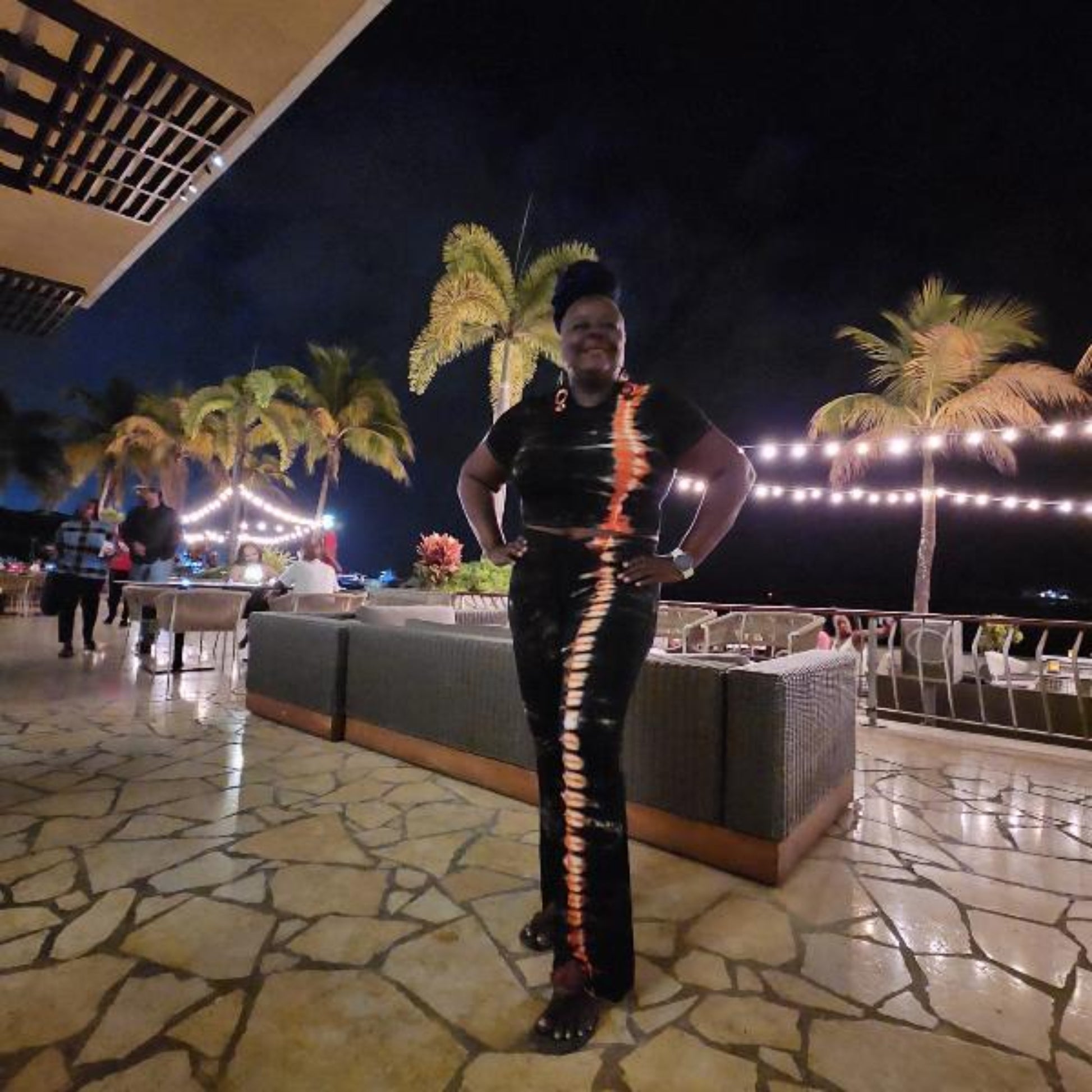 Woman wearing two piece pants set with palm trees in the backround