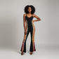 A black sleeveless jumpsuit ,featuring a vibrant tie-dye pattern running down the sides of the legs