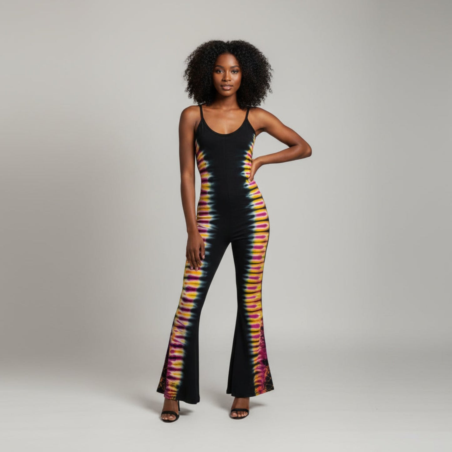 A black sleeveless jumpsuit ,featuring a vibrant tie-dye pattern running down the sides of the legs
