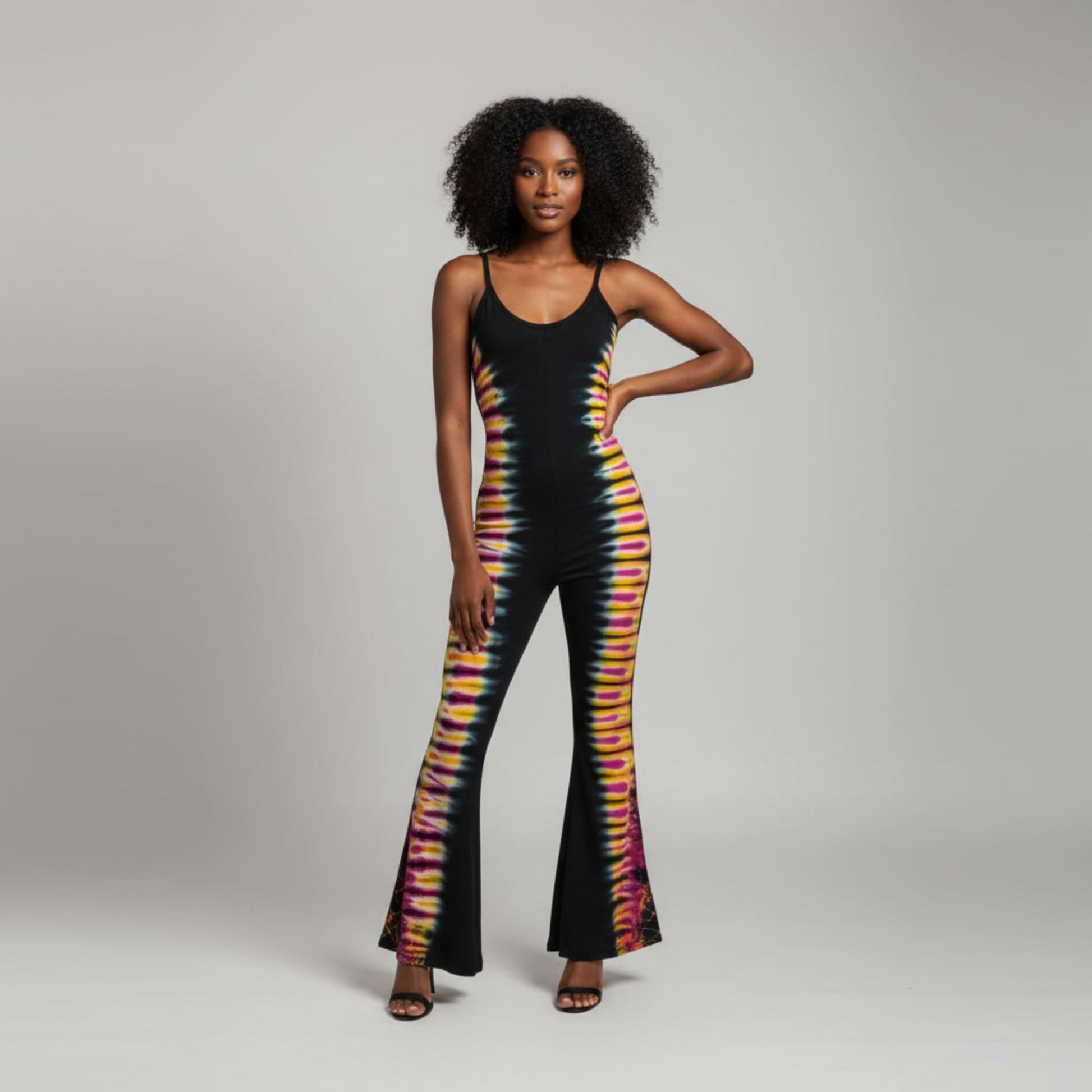 A black sleeveless jumpsuit ,featuring a vibrant tie-dye pattern running down the sides of the legs