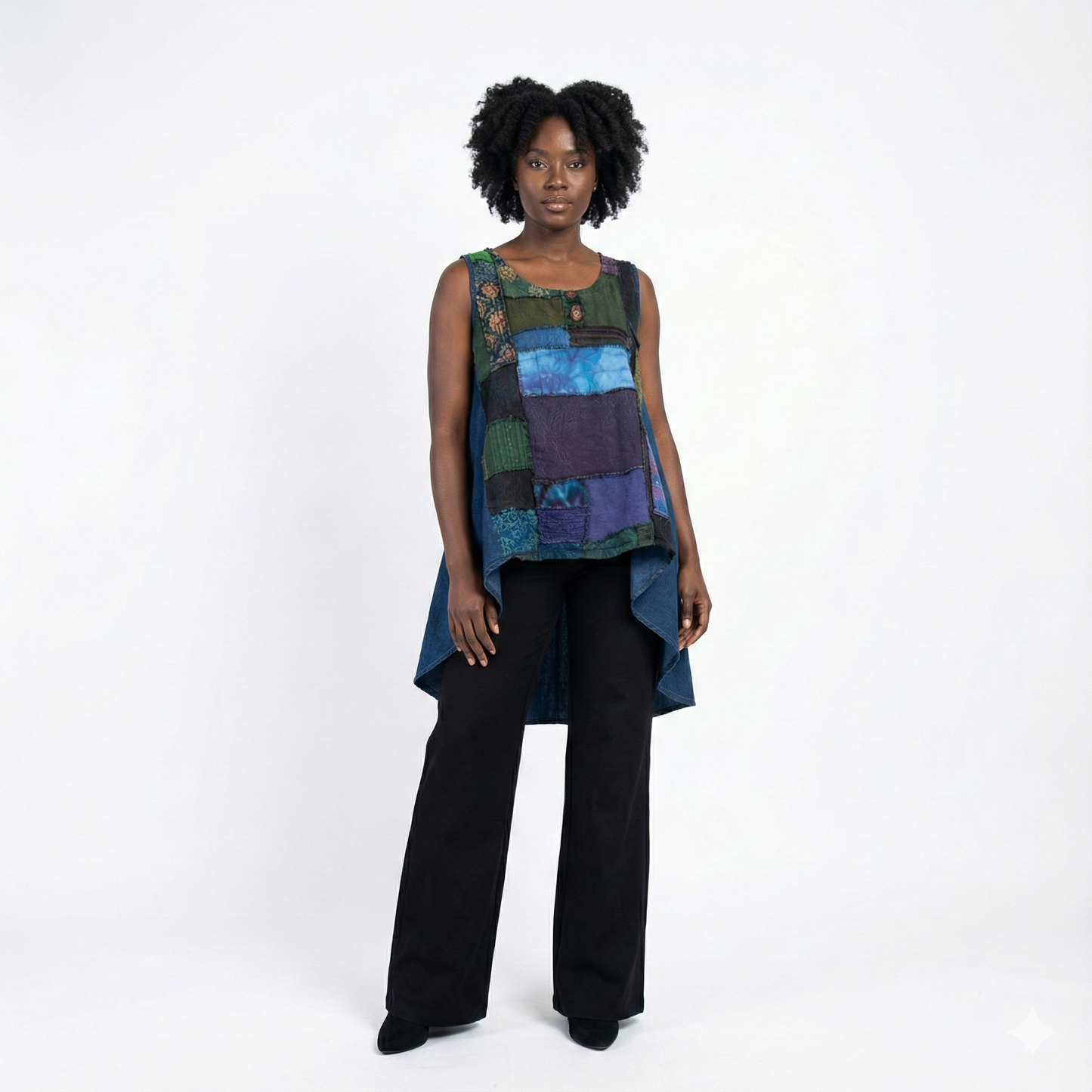 Woman wearing a colorful sleeveless top and black pants on a white background