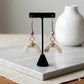 Kenyan handcrafted brass, cowrie shell, and bone drop earrings with arch-shaped bone accents.