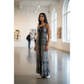 Woman wearing a long, tie dye dress standing in an art gallery.