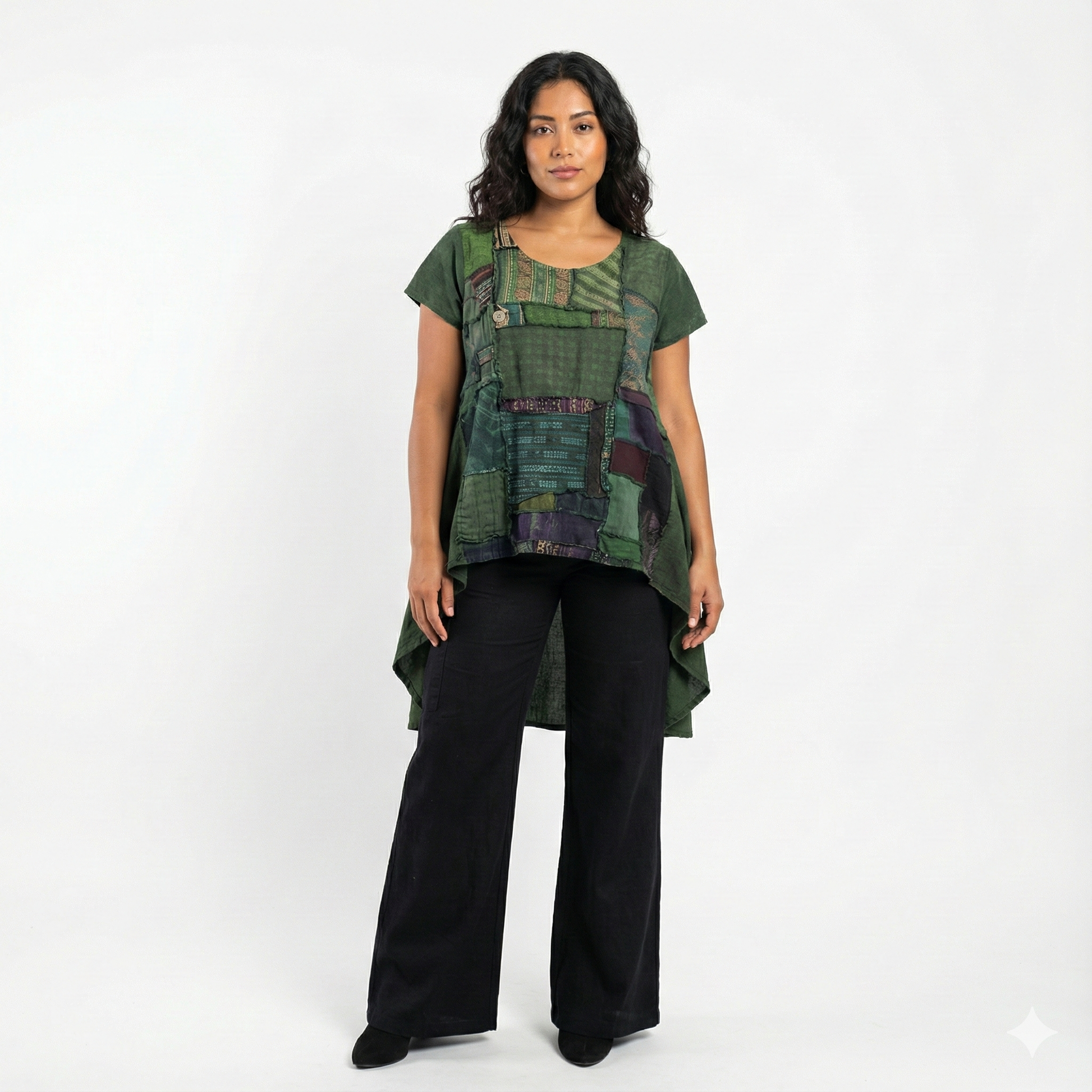 Woman wearing a green patterned top and black pants on a white background