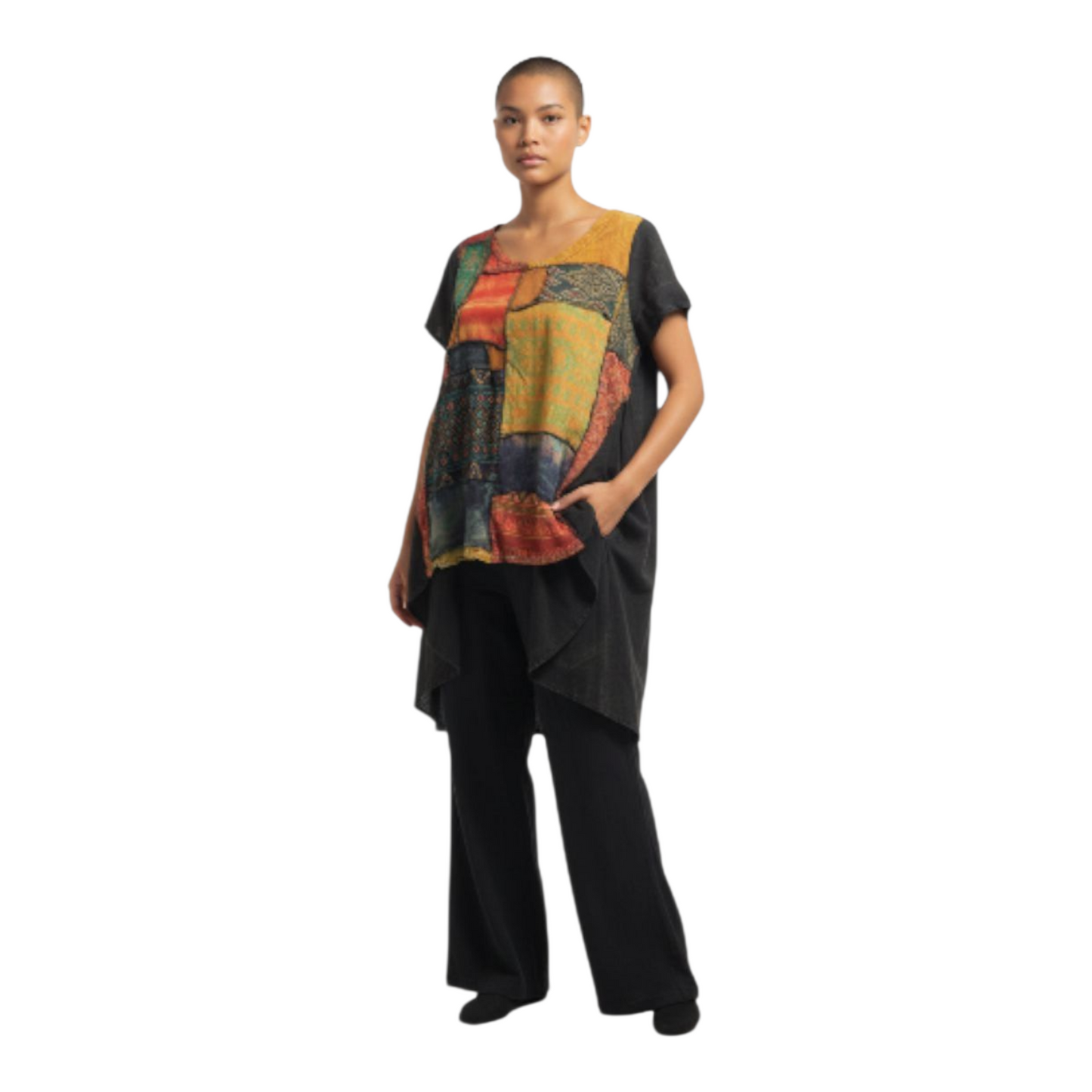 Woman wearing a colorful patterned top and black pants on a white background