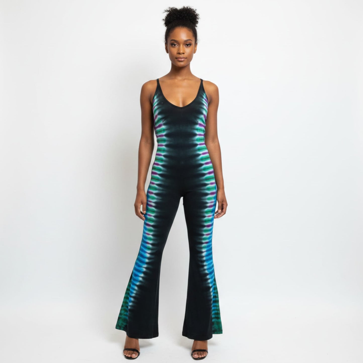 A woman modeling a sleeveless black jumpsuit with a vibrant teal and green tie-dye pattern
