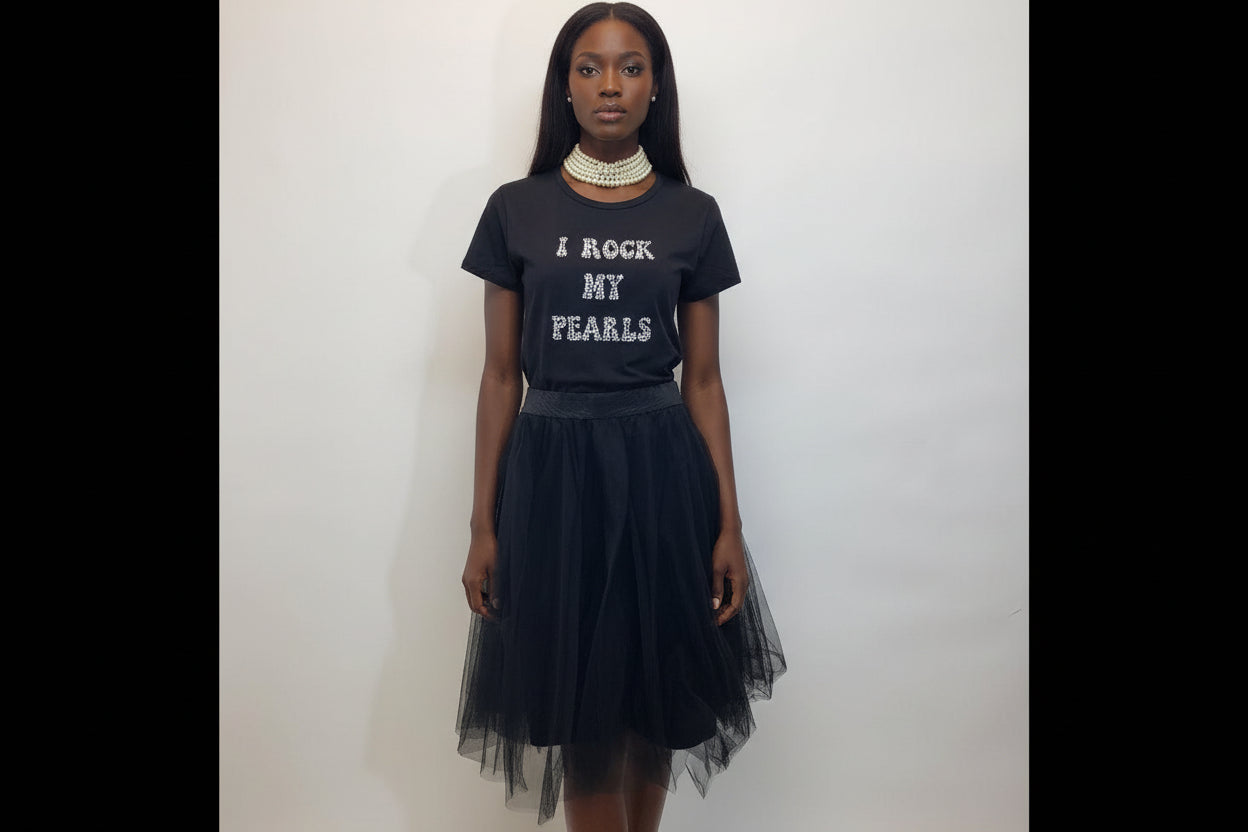 Person wearing a black t-shirt with text and a black tulle skirt on a white background