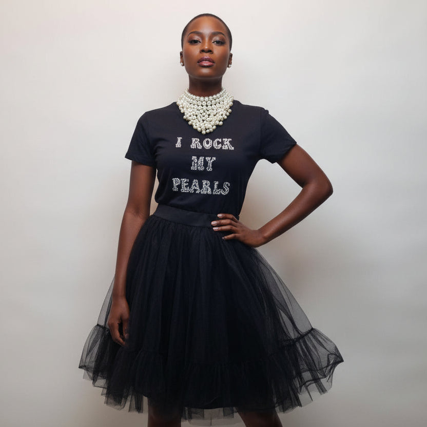 Woman wearing a black t-shirt with 'I Rock My Pearls' text and a black tulle skirt.