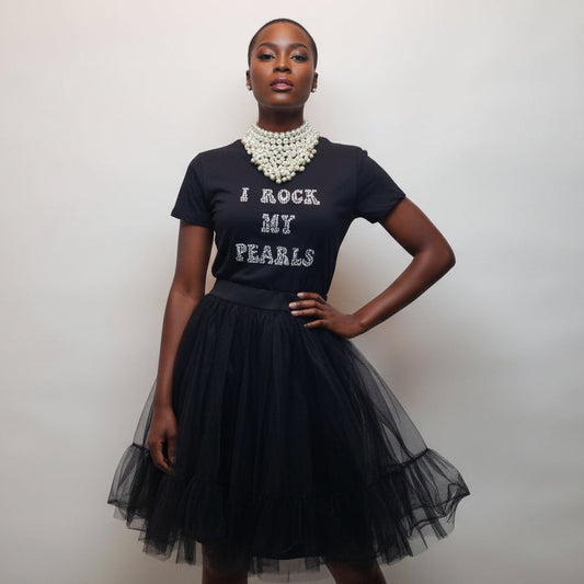 Woman wearing a black t-shirt with 'I Rock My Pearls' text and a black tulle skirt.
