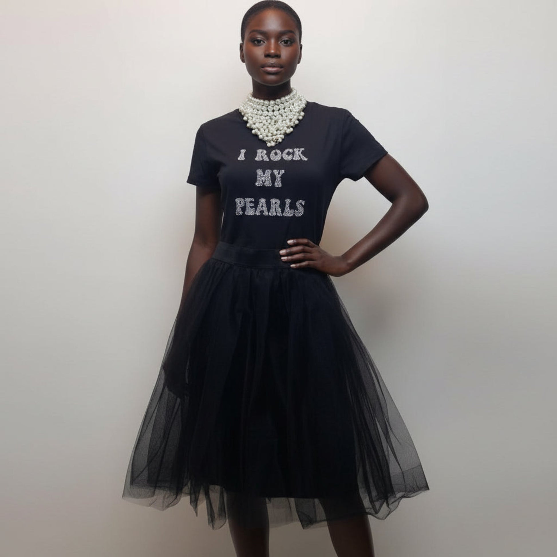 Woman wearing a black dress with 'I Rock My Pearls' text and a tulle skirt.