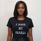 Woman wearing a black t-shirt with 'I ROCK MY PEARLS' text on a plain background