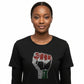 Woman wearing a black 100% cotton t-shirt with  rhinestone Black Power fist red, black, and green.