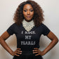 Woman wearing a black t-shirt with 'I Rock My Pearls' text and a necklace.