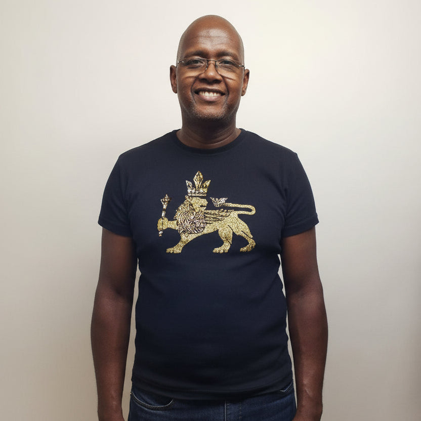 Man smiling in a black 100% cotton t-shirt with a gold lion wearing a crown graphic.